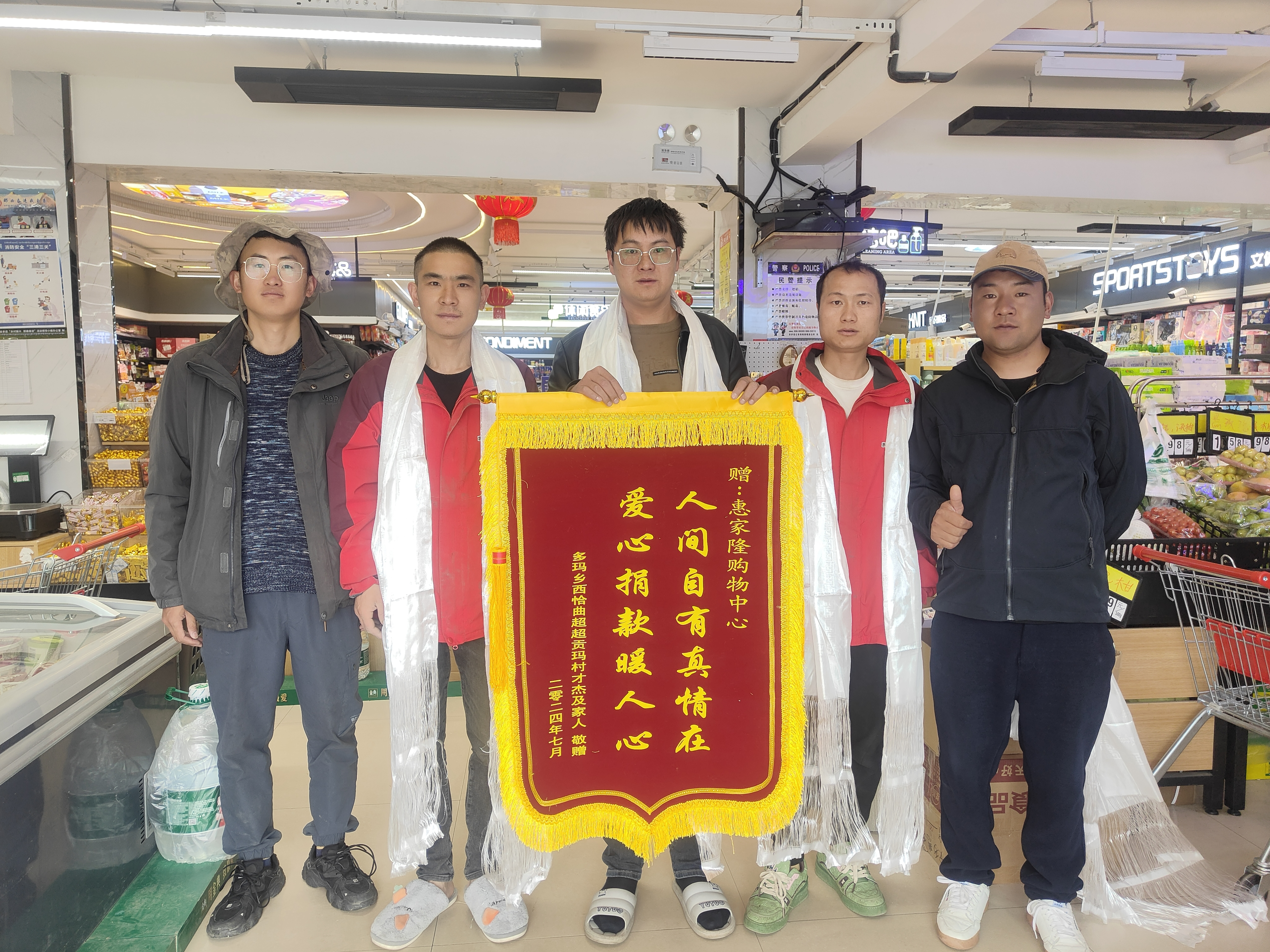 圖為駐村工作隊隊長、第一書記王劉恩和駐村工作隊隊員弟古向愛心企業(yè)敬獻(xiàn)錦旗03.jpg