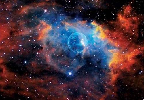 這是著名的“氣泡星云”（Bubble Nebula），這是一個(gè)灰塵氣體星云，其直徑為10光年，相當(dāng)于60萬億英里。氣泡星云是由一顆恒星燃燒時(shí)的脫離物質(zhì)構(gòu)成，恒星燃燒時(shí)可釋放出太陽數(shù)百倍亮度的光芒。該星云距離地球11000光年，位于仙后星座。