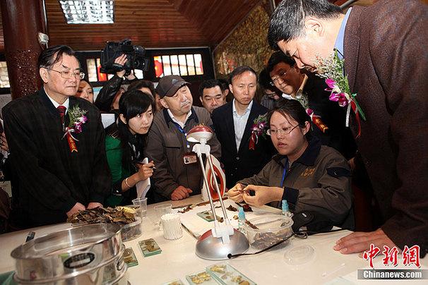 重慶大足石刻千手觀音搶救性維修保護工程現場，國家文物局局長單霽翔（右一）現場了解舊金箔的處理程序。