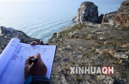 青海湖國家級自然保護區(qū)管理局工作人員在記錄鳥類觀測數(shù)據(jù)。新華社　張宏祥　攝