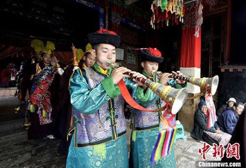 西藏山南地區(qū)桑耶寺僧人在神舞表演前吹響嗩吶。（李林/攝）