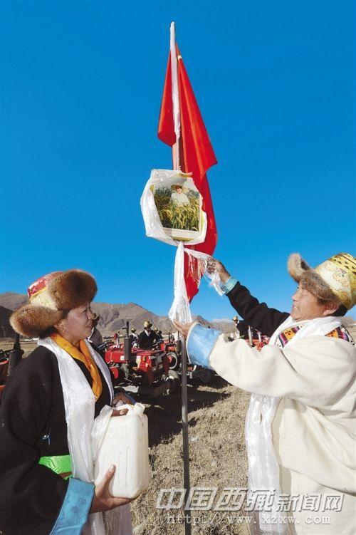 開耕儀式上，桑珠林村村民向領(lǐng)袖像敬獻(xiàn)潔白的哈達(dá)，祝福祖國繁榮昌盛。記者 旦增 攝