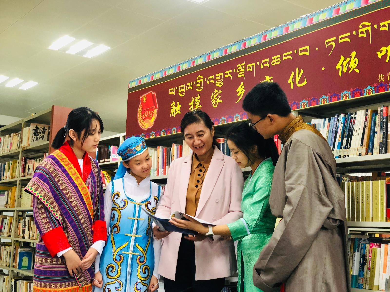 yj1123p02共青團西藏自治區(qū)委員會副書記格桑卓瑪，在武漢西藏中學(xué)設(shè)立“觸摸家鄉(xiāng)變化·傾聽黨的聲音”主題書刊欄處向?qū)W生們介紹相關(guān)書籍。.jpg