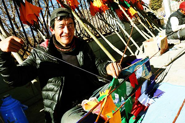 圖為：1月23日上午，來自西藏日喀則市南木林縣農(nóng)民旦增平措，在藏歷火雞新年前來山南縫制、銷售經(jīng)幡樹。他說，每天可以賣出30棵左右，每棵平均賣300元至150元不等，收入可觀。曲杰 攝.jpg